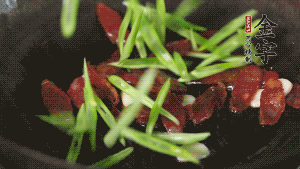 先后下香腸片、四季豆絲均勻翻炒，加適量清水燜煮一下。