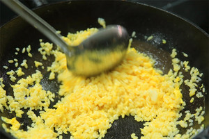 大火加熱炒鍋，再入油，燒到四至五成熱時(shí)倒入雞蛋液，在未凝結(jié)之前，加米飯煸炒，不停翻炒并用鍋鏟將成塊的米飯碾開、撥散。