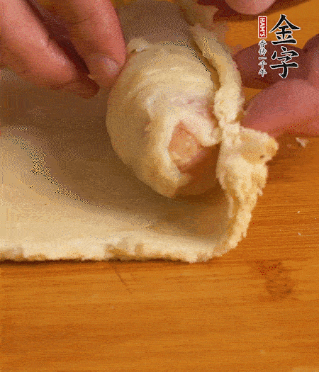 吐司卷起香腸，吐司尾端涂抹少許全蛋液，卷好的吐司表面蘸上蛋液，在裹上一層面包糠，送入預(yù)熱好的烤箱中。